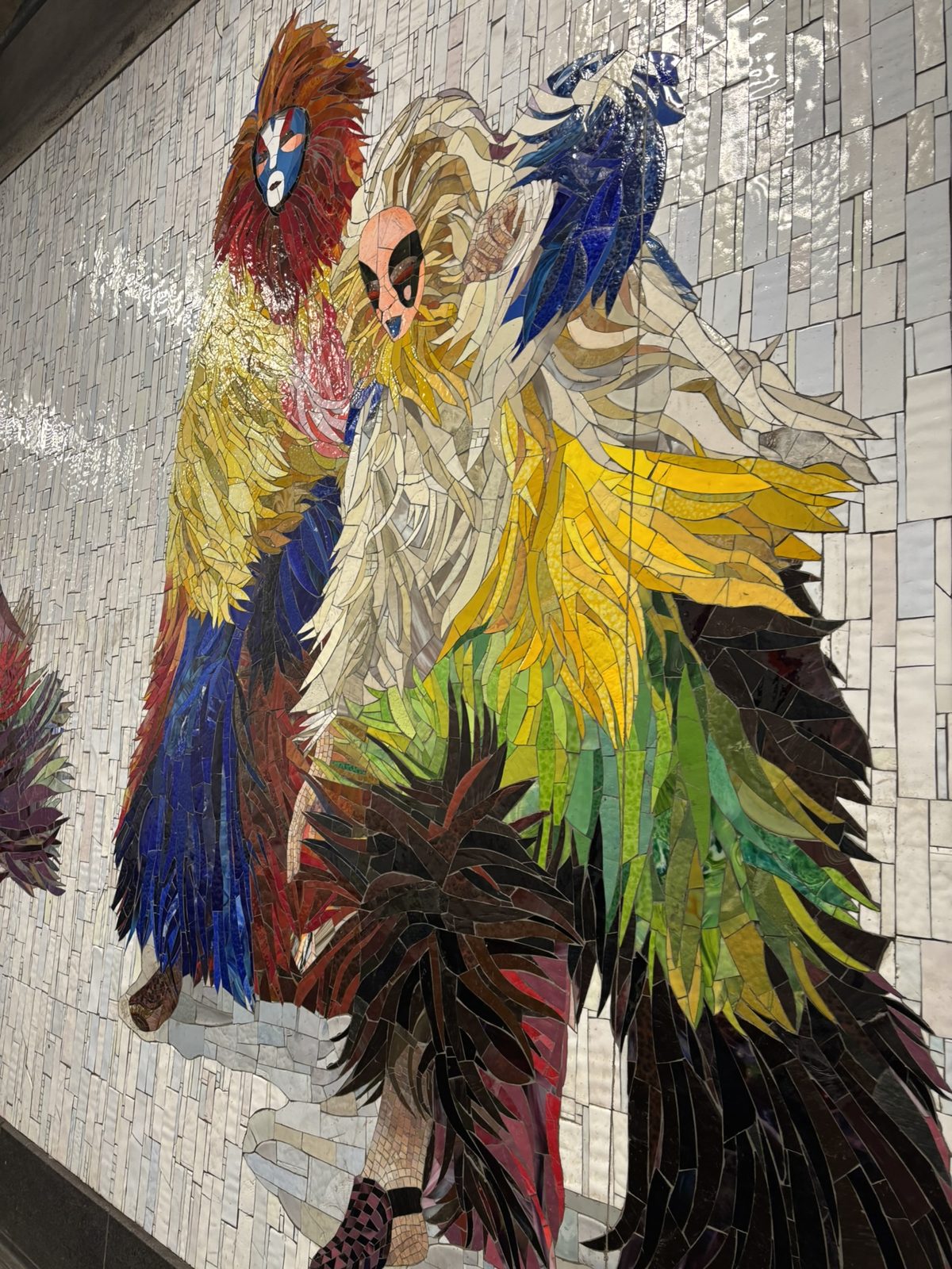 A colorful glass mosaic on a subway station wall